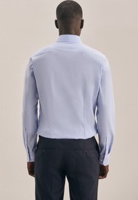 Hellblaues Langarmhemd mit Spread-Kragen, geradem Schnitt und geknöpften Manschetten. Glatte Textur, minimalistisches Design und keine sichtbaren Muster.