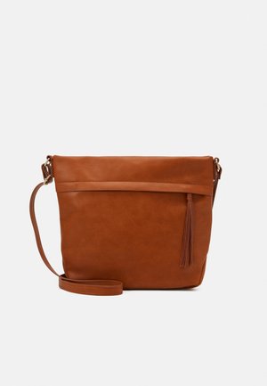 Bruine leren crossbodytas met lange verstelbare riem en decoratieve kwast aan de voorkant tegen een witte achtergrond.
