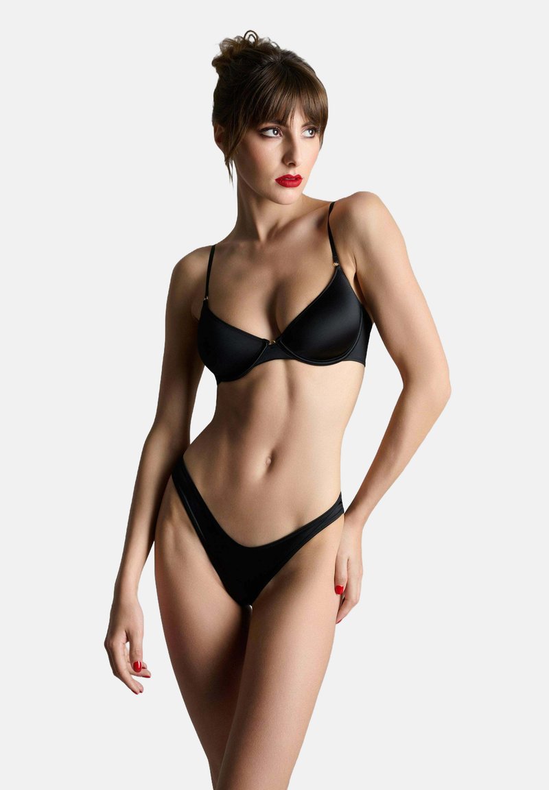 Schwarzes Lingerie-Set bestehend aus einem glatten, gepolsterten BH und einem hochgeschnittenen Tanga. Beide Teile verfügen über dünne Träger und ein minimalistisches Design.