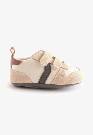 Blød beige og cremefarvet småbørns sko med to velcroremme, mørkegrå sideløb, brun hælflap og tekstureret sål.
