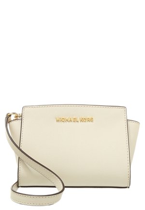 Sac bandoulière Michael Kors en cuir crème avec logo doré et bandoulière ajustable sur fond blanc.