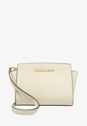 Kremowa skórzana torba na ramię Michael Kors z złotym logo i regulowanym paskiem na białym tle.