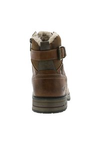 Bottine en cuir marron avec une doublure en fourrure douce, dotée d'une sangle décorative avec boucle et d'une semelle en caoutchouc robuste avec un motif de profil prononcé.