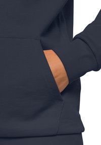 Felpa scura color navy con tasca a marsupio, polsini a coste e tessuto morbido al tatto. Presenta una vestibilità comoda e dettagli di cucitura minimi.