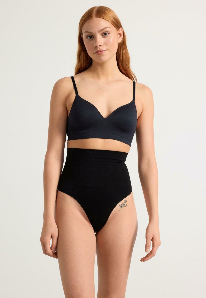 Mutande nere a vita alta abbinate a un bralette grigio scuro. Entrambi presentano una finitura in tessuto liscio e un design minimalista con spalline sottili.