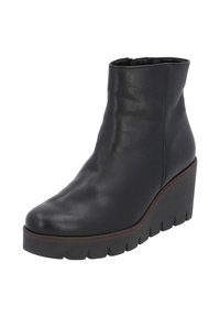 Bottine en cuir noir avec un talon compensé et une plateforme texturée, présentant un bout arrondi et des coutures le long des seams.