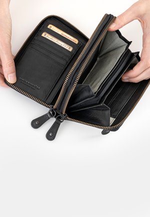 Portafoglio in pelle nera con chiusura a zip. Presenta diversi slot per carte, scomparti e una fodera interna a righe. Le linguette della zip sono accentuate in pelle.