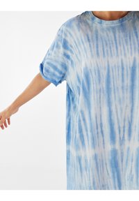 Modré tričko s tie-dye potiskem, volného střihu, krátkými rukávy a kulatým výstřihem. Měkká látka s různými odstíny modré a bílých vzorů.