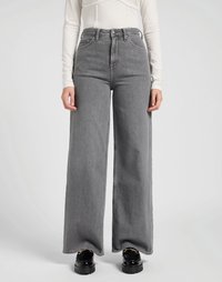 Jeans de pierna ancha en gris, confeccionados en denim, con cintura alta, bolsillos frontales y un dobladillo limpio. Combinados con zapatos de plataforma negros y gruesos.