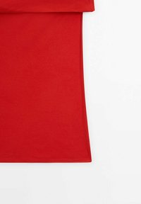 T-shirt en coton rouge à la texture douce, avec un col rond et des manches courtes. L'ourlet est droit et le tissu semble flexible.