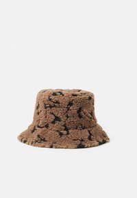 Brun bucket hat lavet af blødt fleece med en struktureret overflade. Har et sort abstrakt mønster over det hele og en bred, fleksibel skygge.