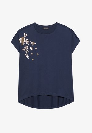 Marineblå kortærmet t-shirt med blomsterbroderi i guld og hvid på venstre side, med en let afrundet sømkant.