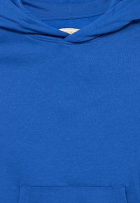 Μπλε βαμβακερό φούτερ με κουκούλα, με υφή στην επιφάνεια, μπροστινή τσέπη και κορδόν ια στην κουκούλα. Απλός σχεδιασμός χωρίς ορατά σχέδια ή διακοσμητικά.