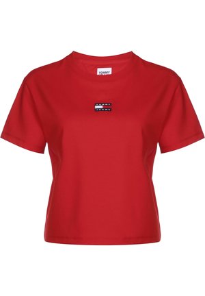 Red short-sleeve cotton T-shirt with crew neck and small rectangular Tommy Jeans logo patch centered on the chest.
