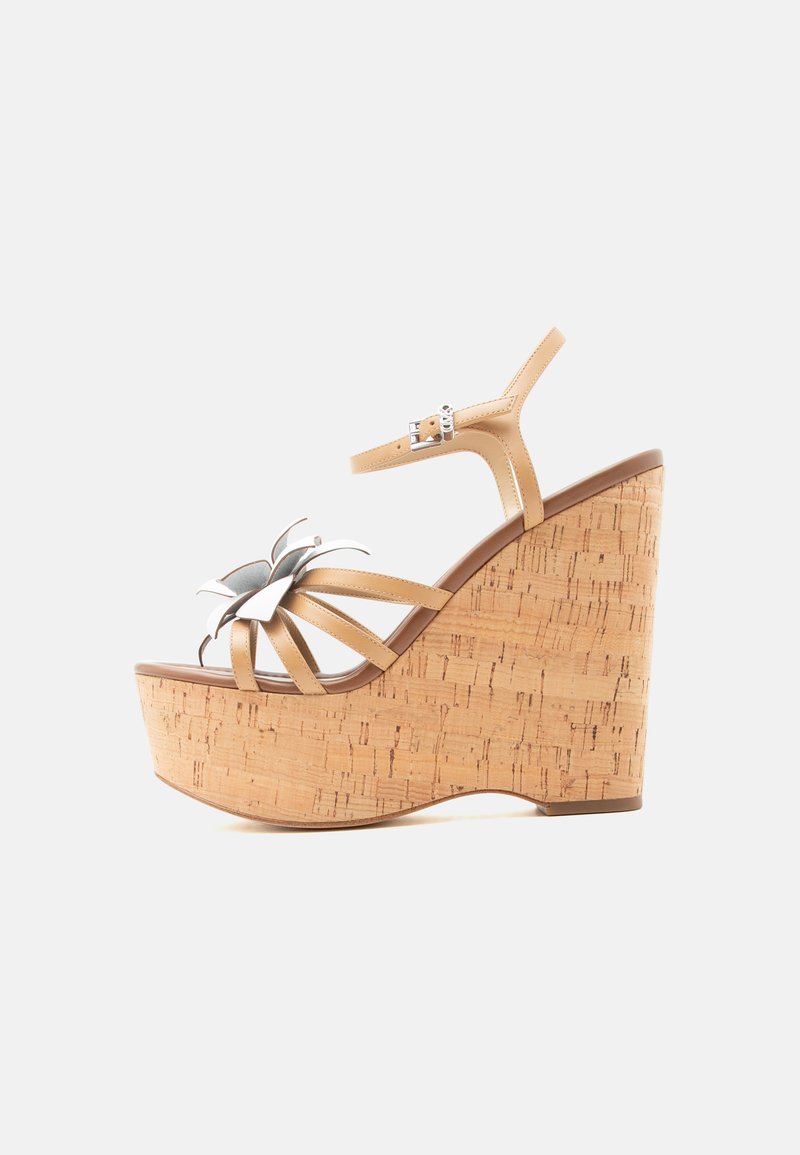 Μπεζ πλατφόρμα πλατφόρμας με φελλό, λουράκι στον αστράγαλο και ασημένιο διακοσμητικό με λουλούδια στο μπροστινό λουράκι, εμφανιζόμενο σε πλάγια όψη.