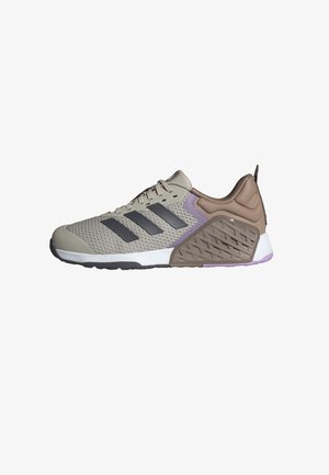 Beige athletic shoe with gray accents, textured mesh upper, padded collar, and dual-density sole featuring a patterned design and purple details.
