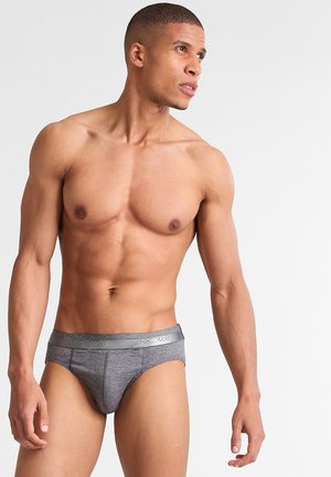 Boxer grigi con una superficie liscia, dotati di un elastico con logo in vita. Il design è aderente e minimalista.