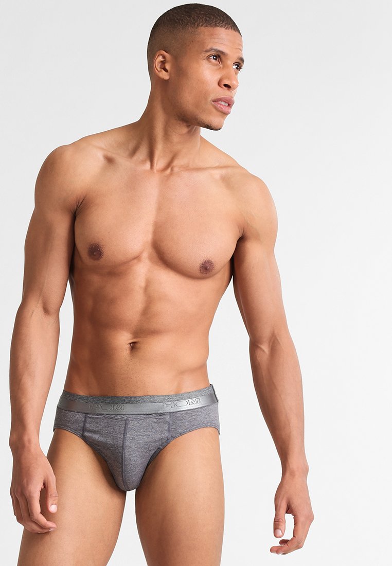 Boxer grigi con una superficie liscia, dotati di un elastico con logo in vita. Il design è aderente e minimalista.