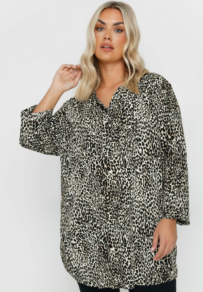Camicia a maniche lunghe con stampa leopardata nei toni beige e nero, caratterizzata da una vestibilità ampia, un colletto e due tasche frontali.