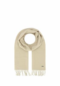 Écharpe beige en matériau doux avec un design circulaire, présentant des bords frangés et une petite étiquette de logo sur un côté.