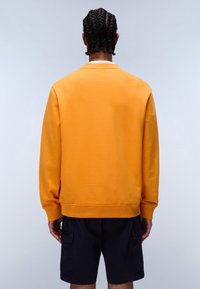 Orange sweatshirt lavet af blødt stof, med rund halsudskæring og ribbede manchetter. Bæres med mørkeblå cargoshorts.