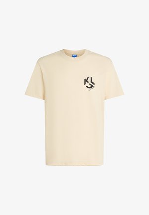 Krema barve bombažna majica s kratkimi rokavi, ki na levem prsnem delu nosi črn geometrijski logotip. Gladka tekstura, standardna prileganje.