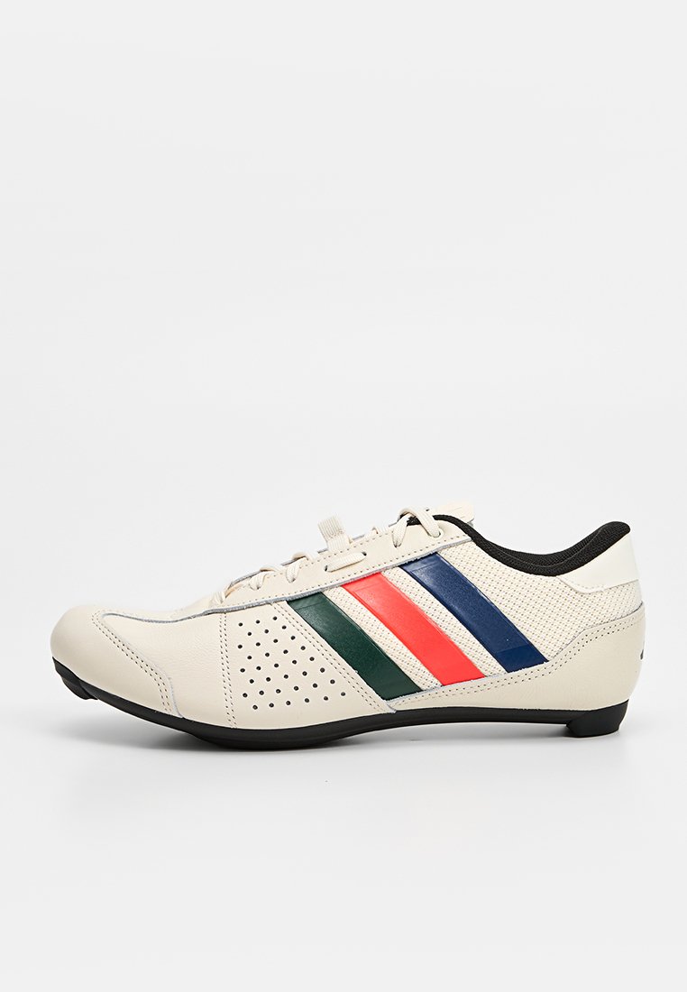 Kremowy sneaker z zielonymi, czerwonymi i niebieskimi paskami, czarną podeszwą, perforowanym boku i sznurowanym zapięciem, przedstawiony z zewnętrznej strony.