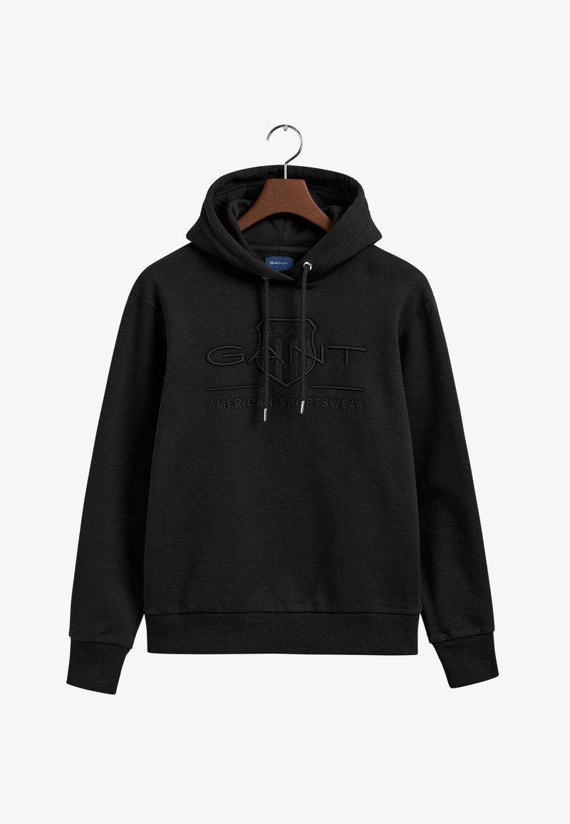 Felpa nera con cappuccio e cordino, caratterizzata da un logo e un testo in rilievo. Realizzata in morbido cotone, presenta polsini e orlo a costina.