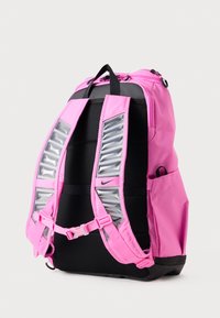 Mochila rosa con detalles en negro, que cuenta con correas acolchadas, elementos reflectantes, un asa superior y bolsillos laterales para un almacenamiento adicional.