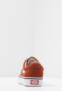 Röda mocka Vans-sneakers med vita detaljer, rund tå, vadderad krage och svart gummisula. Logomärke på hälen.