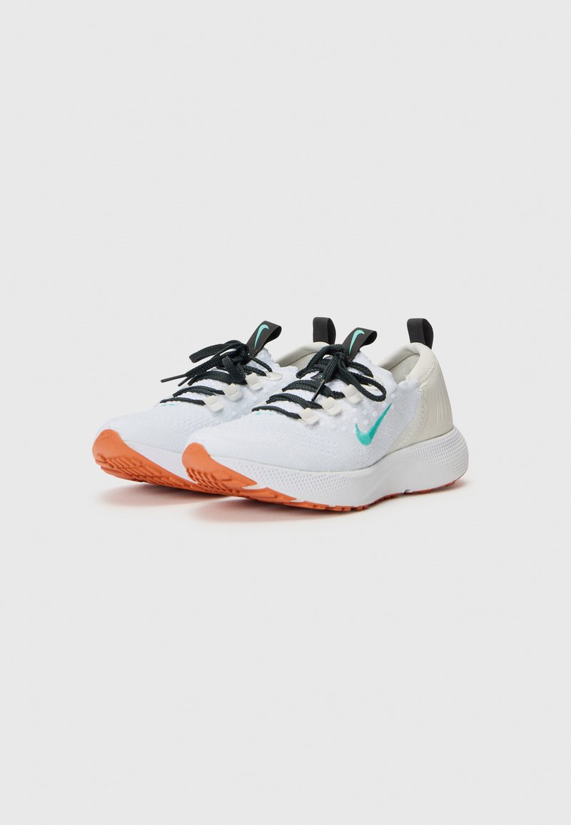 Białe buty sportowe z teksturowaną cholewką z dzianiny, czarnymi sznurowadłami, turkusowymi akcentami i pomarańczową gumową podeszwą. Posiadają pętelkę na pięcie ułatwiającą zakładanie.