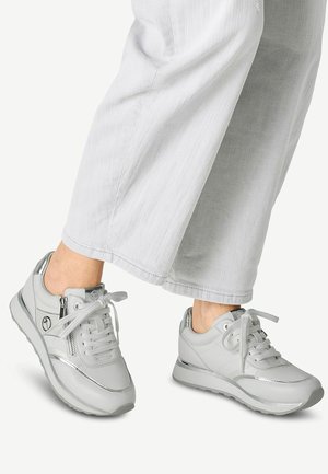 Grå sneakers med en slät läderövre, reflektiva accenter, rund tå, snörning framtill och en dämpad sula för komfort.