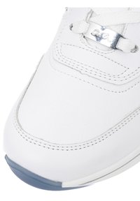 Bout de basket blanc avec détail en cuir double surpiqûre, lacets blancs et étiquette en métal argenté sur les lacets avec logo stylisé, bord de semelle en caoutchouc bleu.