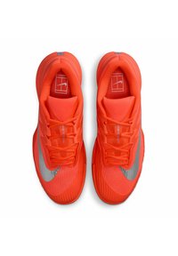 Un paio di scarpe da atletica arancioni brillanti con il logo Swoosh Nike argentato, tomaia in rete e lacci visti dall'alto su sfondo bianco.