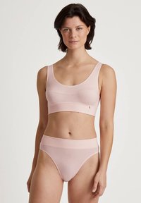 Ensemble de lingerie rose en tissu doux. Le soutien-gorge présente un décolleté arrondi et des bretelles larges ; la culotte est taille haute avec une ceinture lisse.