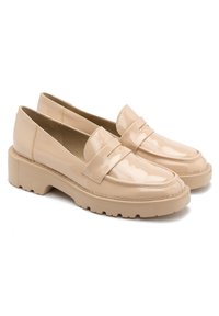 Patentowe beżowe mokasyny na grubej podeszwie, z podniesionym szwem z przodu i detalem kokardy na wierzchu. Gładkie, błyszczące wykończenie.