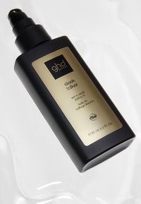 Bouteille en plastique noire avec finition mate, étiquette dorée indiquant "ghd sleek talker", distributeur à piston, capacité de 95 ml, forme rectangulaire élégante.