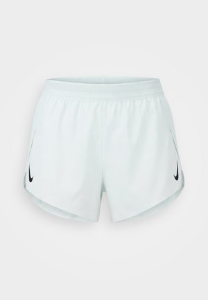 Biele športové šortky s elastickým pásom a bočnými rozparkami, s čiernymi logami Nike Swoosh na oboch nohách.