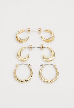 Kuldtooni kõrvarõngaste komplekt sisaldab kolme paari: ühes on pärlid, kahes on poolkuu kujund, ja ühes on tekstuuriga rõngasdisain, kõik peegeldavad poleeritud viimistlust.