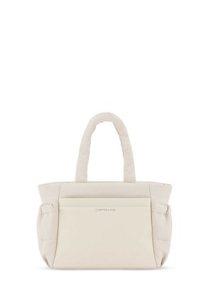 Beige tote bag with a padded design, two short handles, a front pocket, and subtle brand logo. Soft texture and minimalist shape.