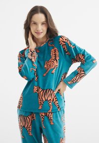 Conjunto de pijama turquesa que presenta un patrón repetido de tigres naranjas. La tela parece suave, con un corte holgado y mangas largas.