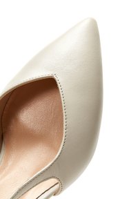 Helle Leder high-heeled Schuhe mit spitzem Zeh und offenem seitlichen Ausschnitt, die eine glatte Textur und ein minimalistisches Design zeigen.