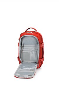 Mochila roja con abertura con cremallera, que cuenta con un interior gris, múltiples compartimentos y una textura suave. Incluye una sección de bolsillo transparente.