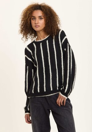 Black and white striped sweater with a soft, textured fabric. Features a crew neck, long sleeves, and a relaxed fit with ribbed cuffs.