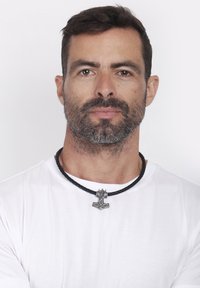 Svart flätad läderhalsband med en silverberlock som har en stiliserad figur. Modellen bär en enkel vit t-shirt.