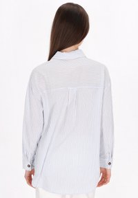 Camicia a maniche lunghe rigata blu chiaro e bianca con colletto, dettaglio sul retro e polsini con bottone. Presenta una vestibilità comoda e un tessuto morbido.