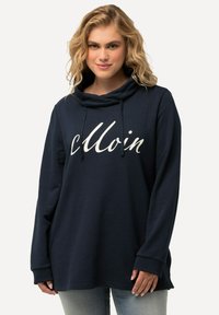 Navy modrý mikina s kapucí a volným střihem, s tkaničkou a bílým kurzívním textem "Moin" na přední straně. Měkká textura.