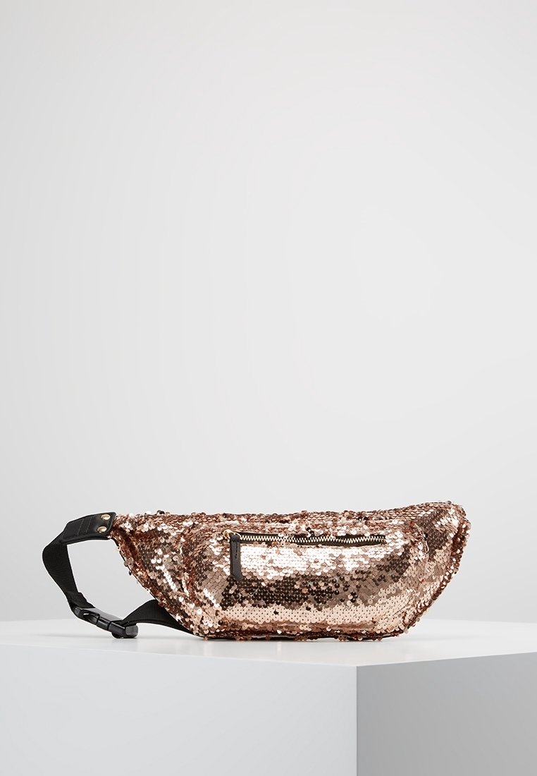 Borsa in vita con paillettes rosa oro e cintura regolabile nera, esposta su un piedistallo bianco contro uno sfondo semplice.