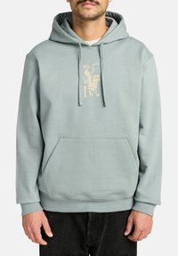 Miętowa bluza z kapturem, wykonana z miękkiego materiału, z przednią kieszenią typu kangur i wyszywanym wzorem tygrysa na piersi.