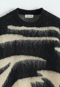 Pull en tricot noir et beige, fuzzy, avec un motif abstrait et un col rond côtelé, taille M, étiqueté par la marque Frilivin.